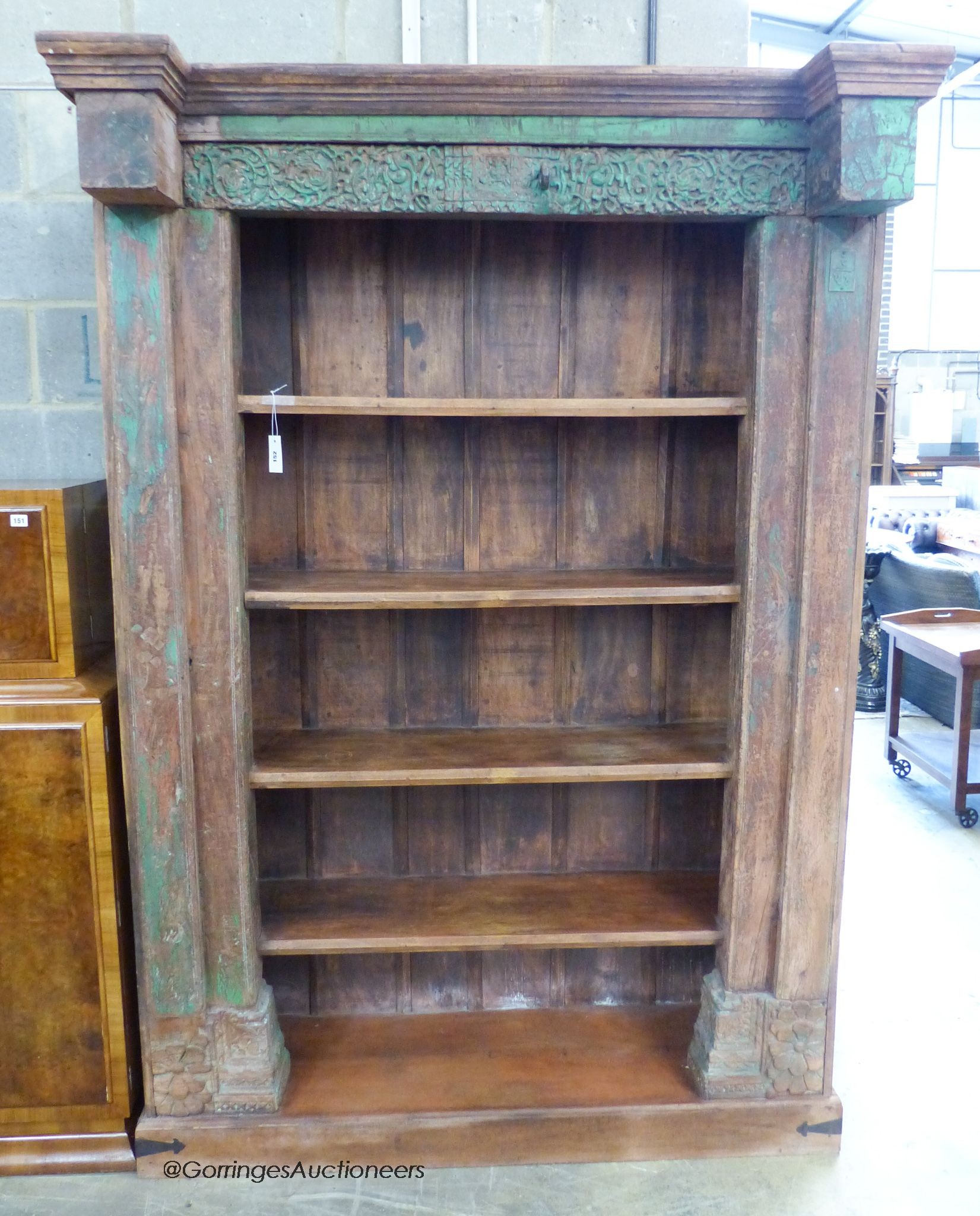 An Indian carved painted hardwood open bookcase, length 146cm, depth 55cm, height 220cm
